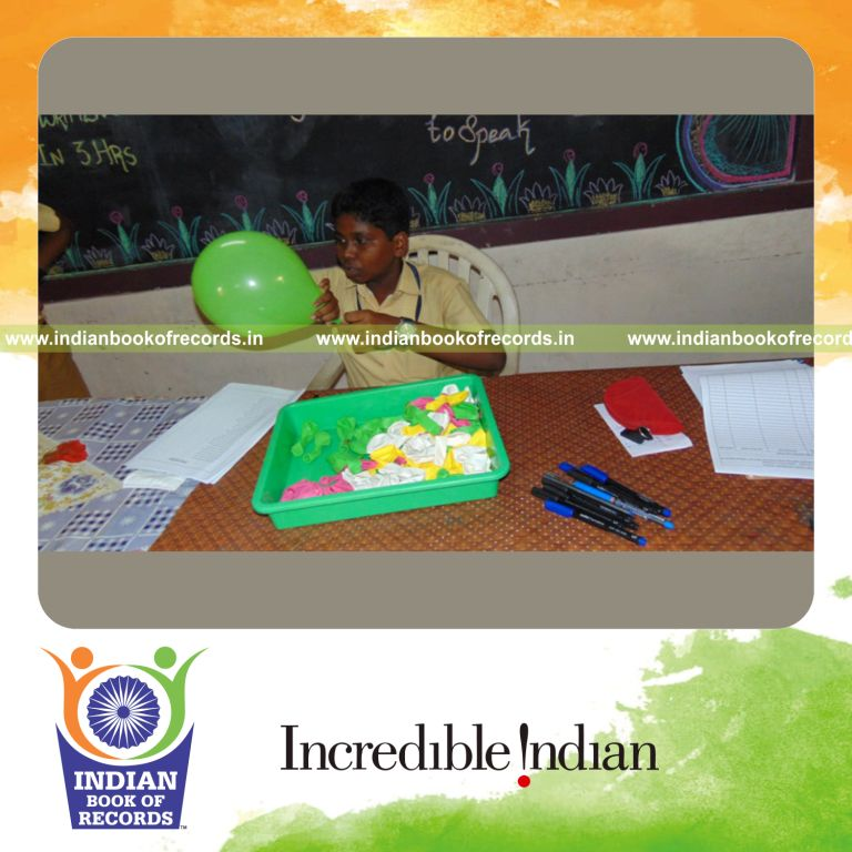 minor male blowing balloons and writing captions for Indian Book of Records