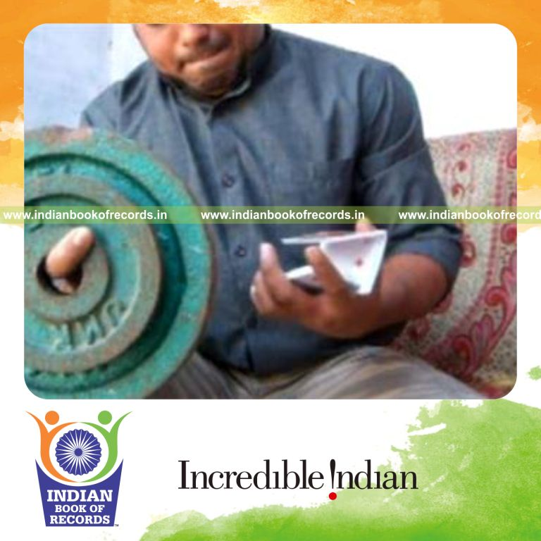 individual performing brian twist card cuts while holding 20 pound weight plate for record in Indian Book of Records
