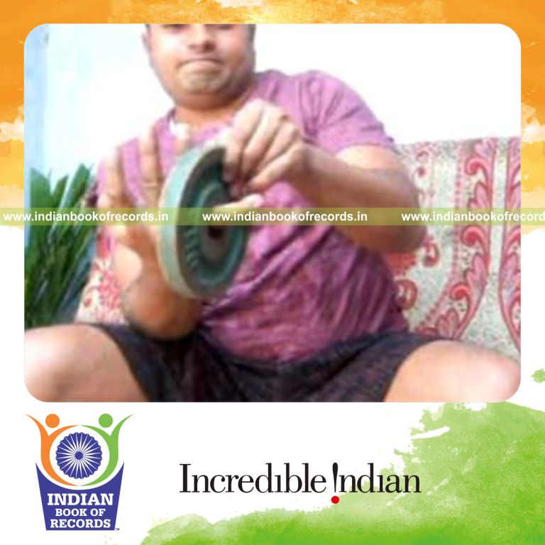 individual performing brian twist card cuts while holding two weight plates for record in Indian Book of Records