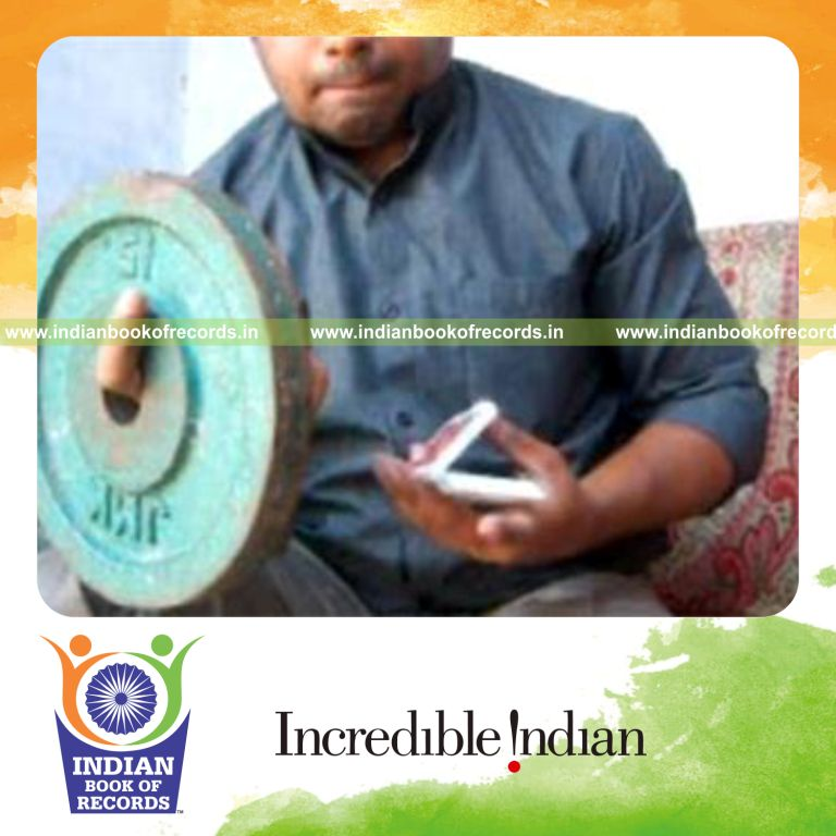 individual performing charlier card cuts while holding weight plates for record in an Indian Book of Records
