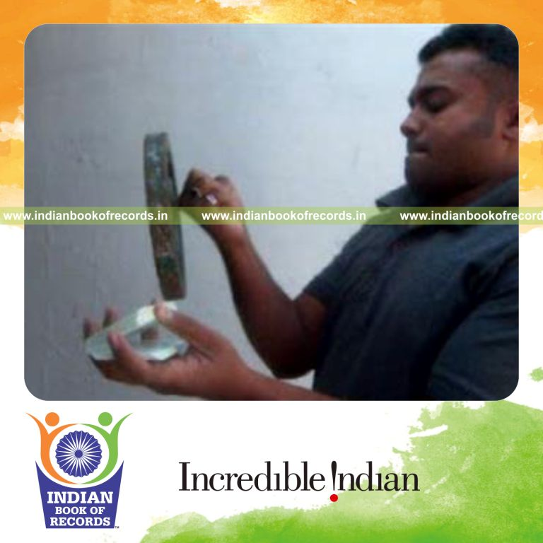 individual performing charlier cuts while holding weight plate on finger for record in Indian Book of Records
