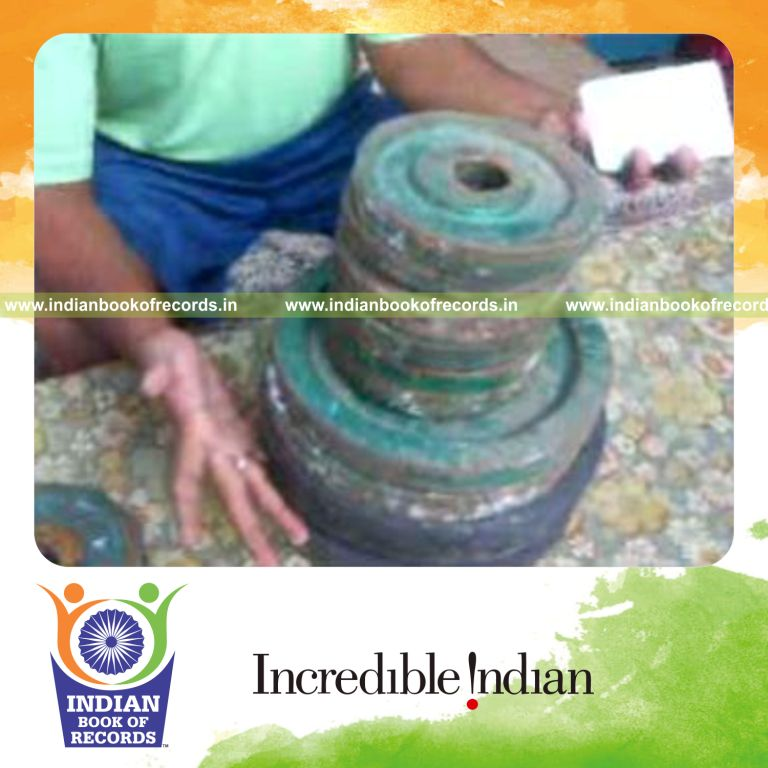 individual performing charlier cuts with pinky held between weight plates for record in Indian Book of Records
