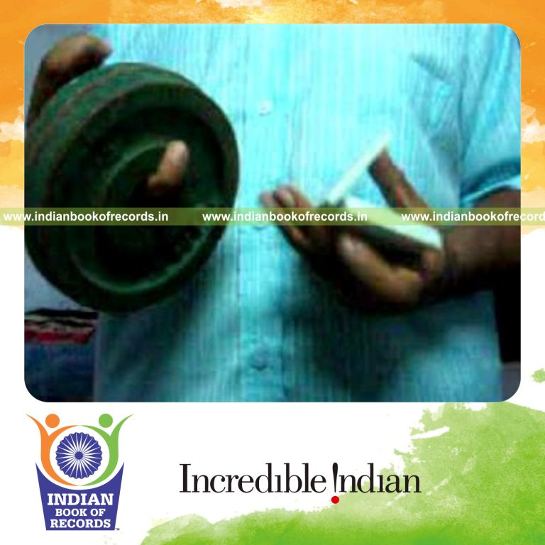 individual performing charlier card cuts while holding weight plates on pinky finger for record in Indian Book of Records