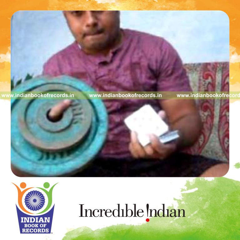 individual performing chen ka card cuts while holding 20 pound weight plate for record in Indian Book of Records