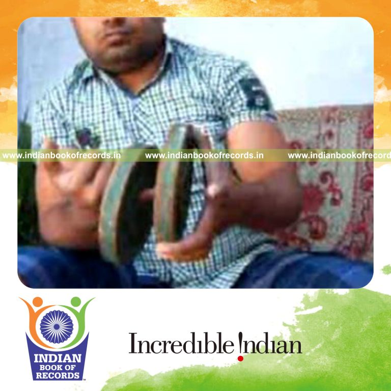 individual performing chen ka card cuts while holding two weight plates for record in Indian Book of Records