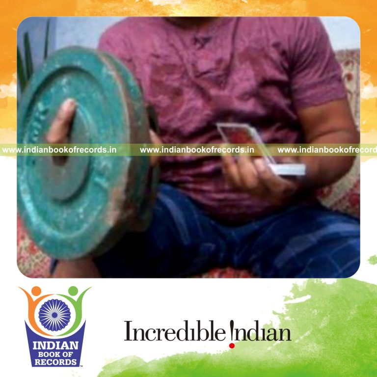 individual performing chen ka card cuts while holding weight plates for record in Indian Book of Records