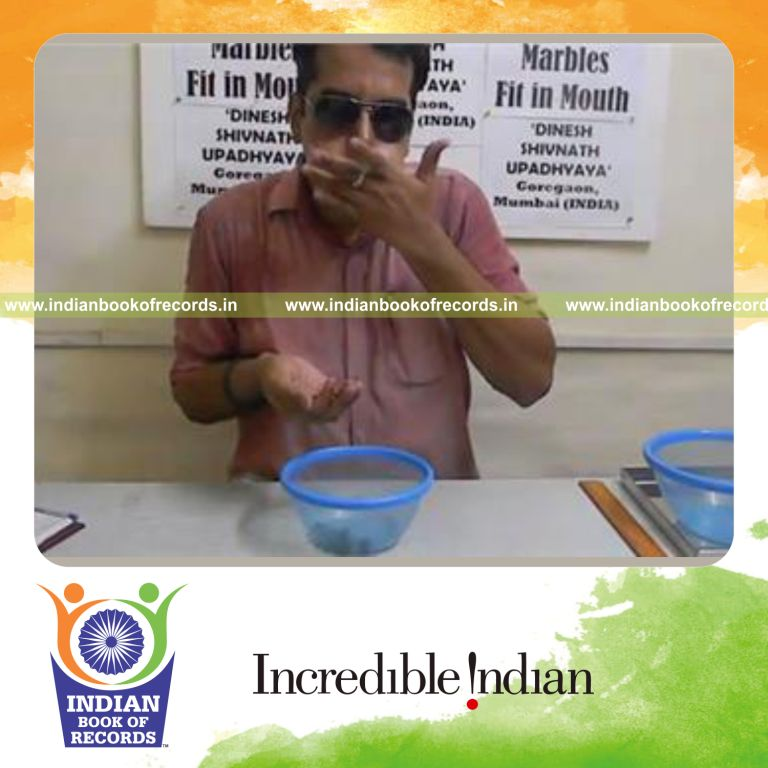 individual fitting glass marbles in mouth for record in Indian Book of Records