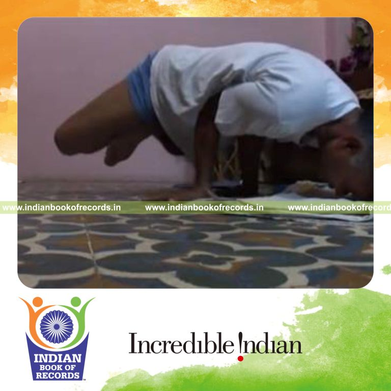 individual performing head dips while holding combined lotus and peacock pose for record in Indian Book of Records