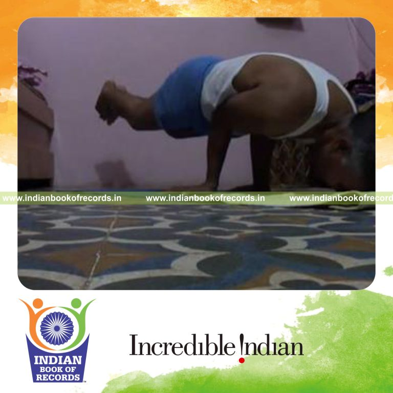 individual performing head dips while holding peacock pose for record in Indian Book of Records