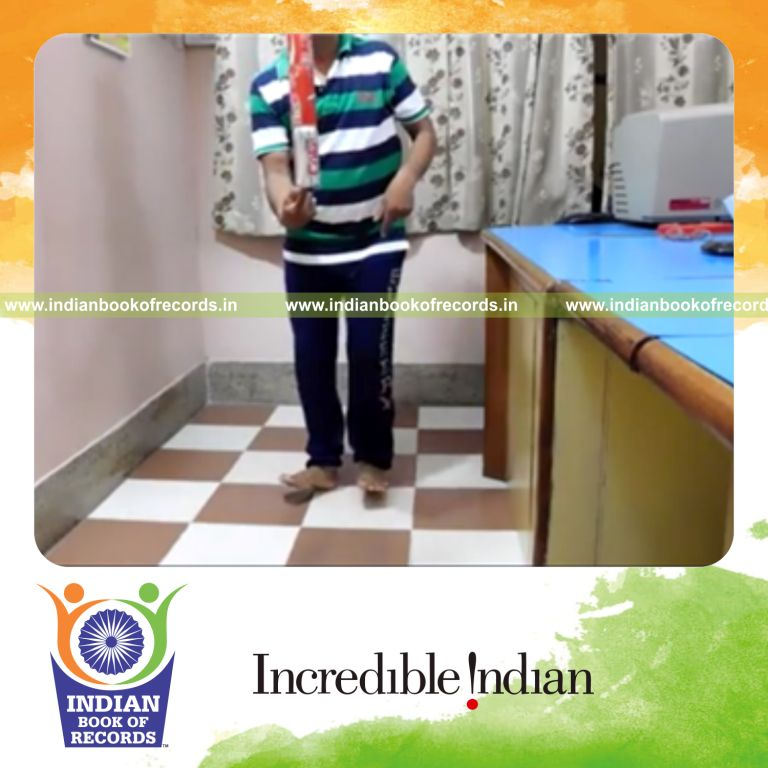 individual rotating on heels while balancing five cans on index finger for record in Indian Book of Records