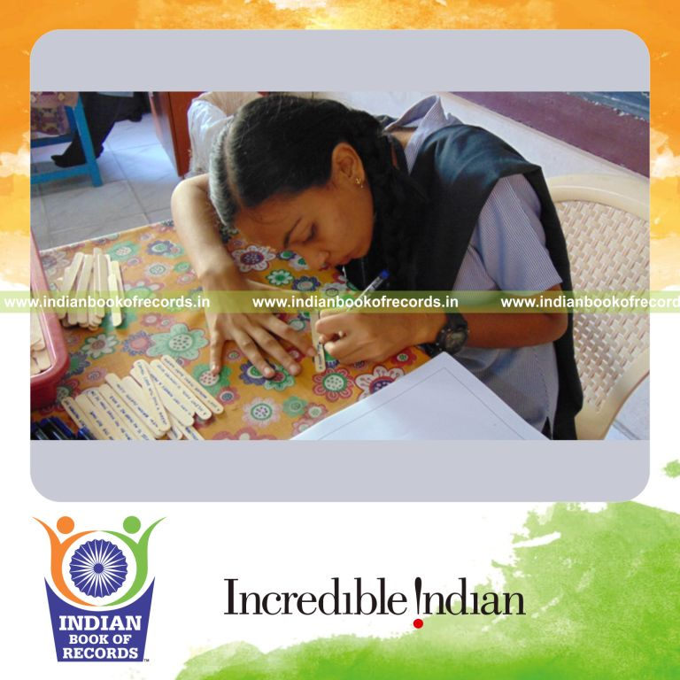 minor female using ice sticks for caption writing for Indian Book of Records
