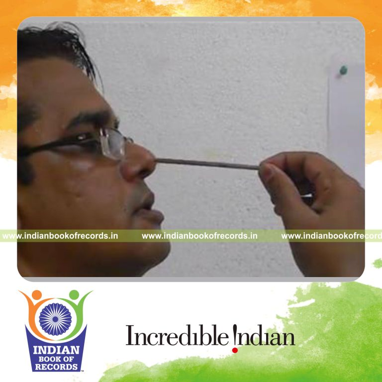 individual inserting nail into nose multiple times in one minute for record in Indian Book of Records