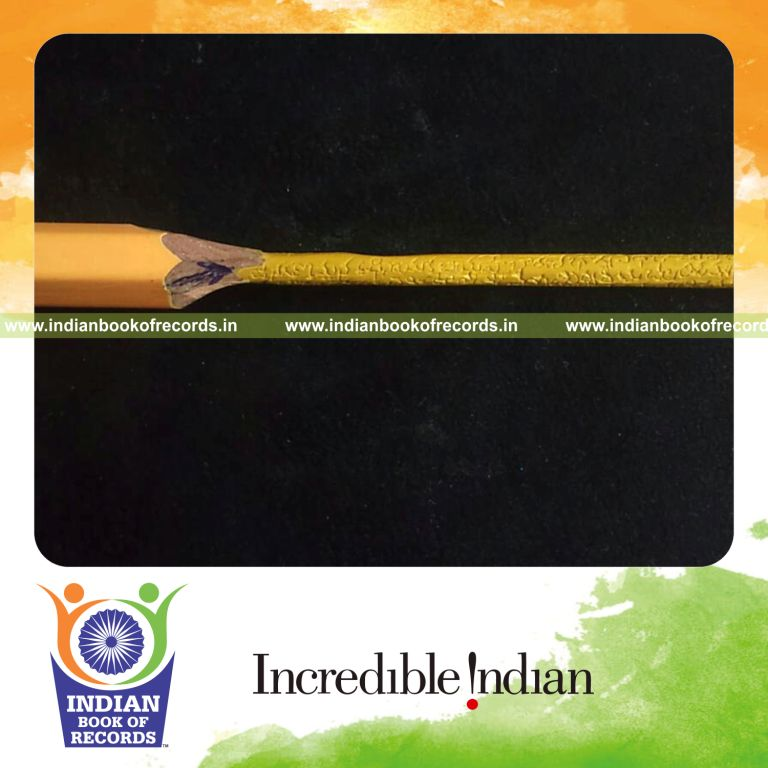 male individual writing national anthem words on pencil lead for record in Indian Book of Records