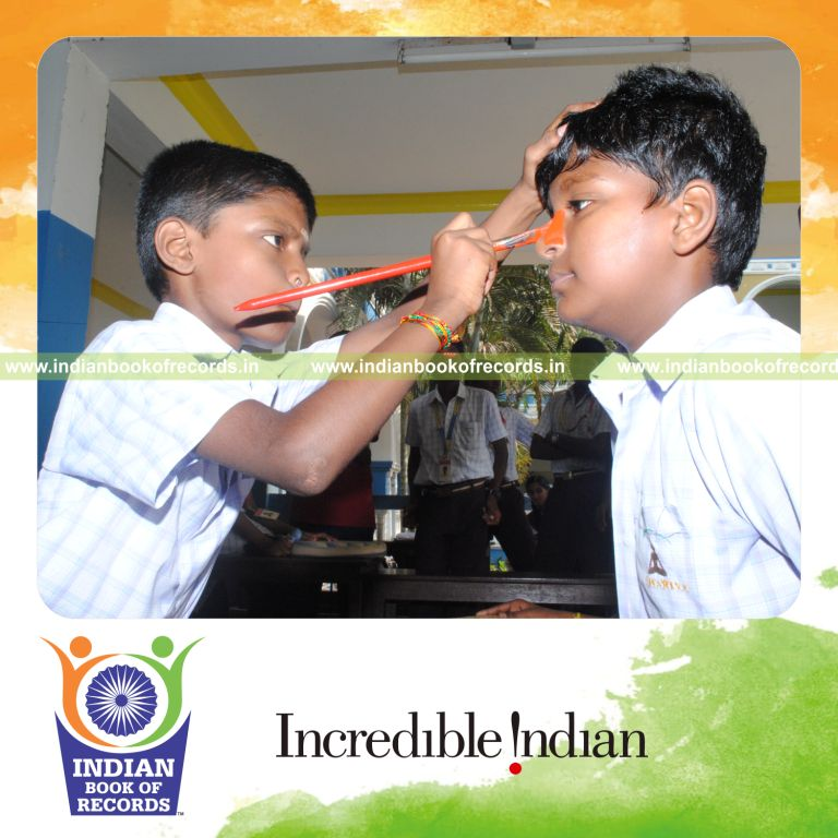young male painting noses with red color within three hours for record in Indian Book of Records