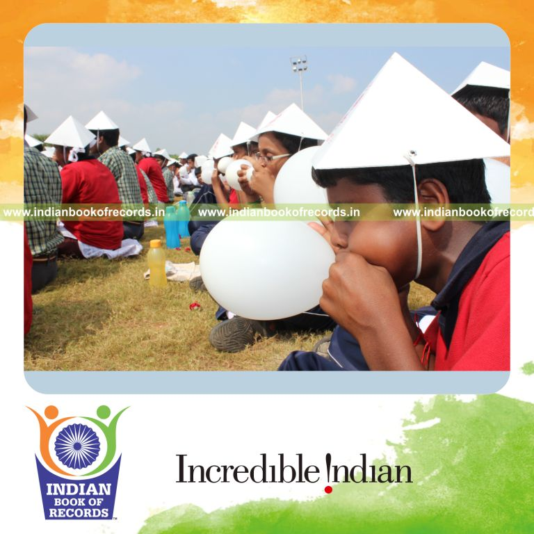 group of people blowing balloons simultaneously at single venue for record in Indian Book of Records