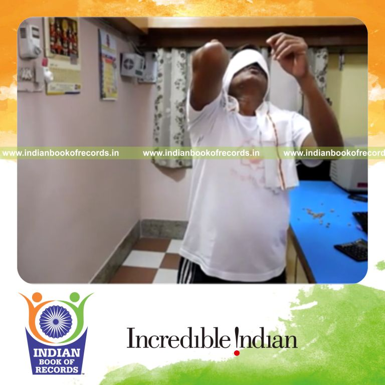 individual balancing peanuts on elbow and catching while blindfolded for record in Indian Book of Records