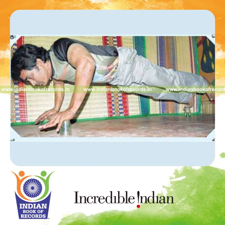 male individual performing push ups on tea glasses within thirty seconds for record in Indian Book of Records