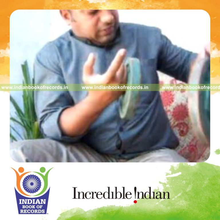 individual performing reverse revolution card cuts while holding weight plates for record in Indian Book of Records