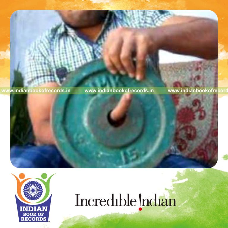 individual performing revolution card cuts while holding 20 pound weight plate for record in Indian Book of Records