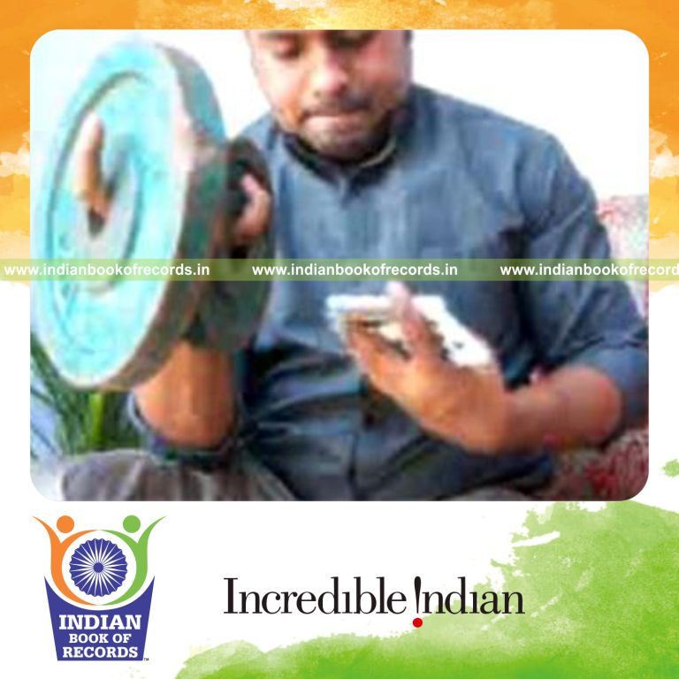 individual performing revolution card cuts while holding weight plates for record in an Indian Book of Records