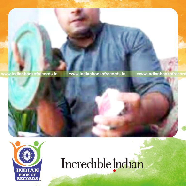 individual performing revolution 2 card cuts while holding weight plates for record in an Indian Book of Records