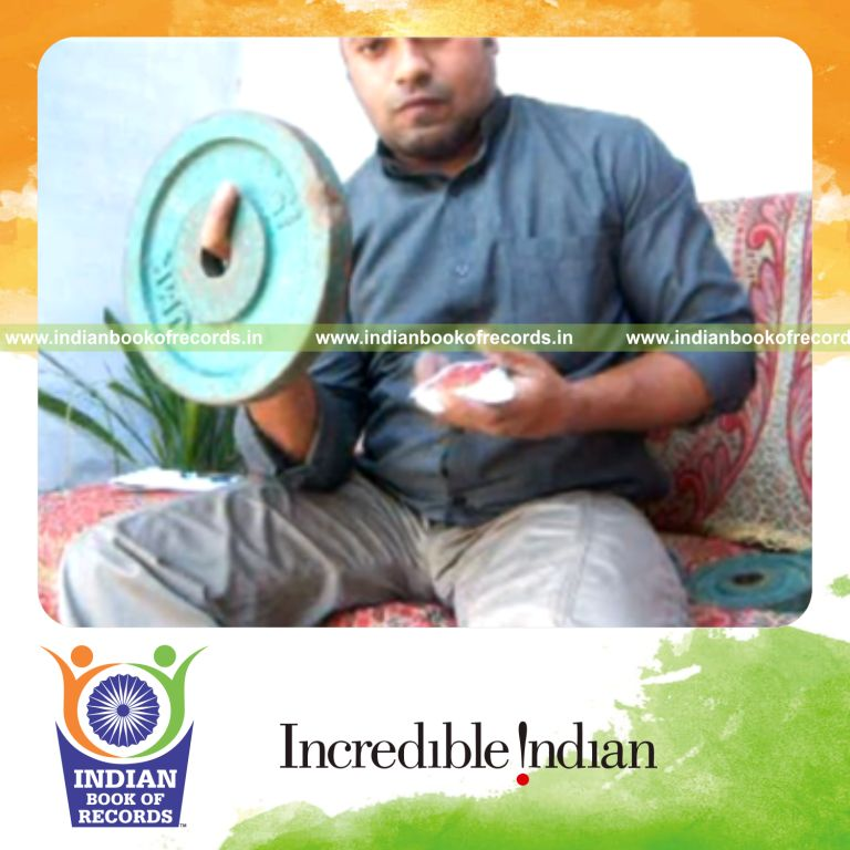 individual performing sabers revo flipped card cuts while holding weight plate for record in Indian Book of Records