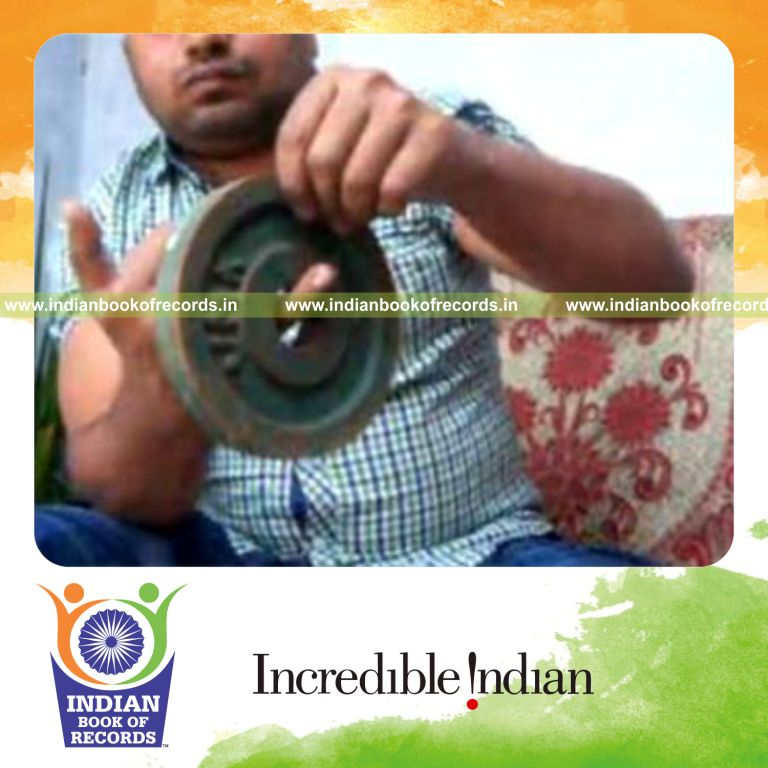 individual performing sabers rollback card cuts while holding weight plates for record in Indian Book of Records