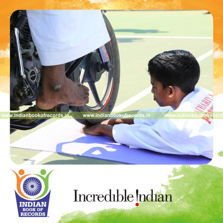 young male performing stunt with motorcycles over fingers within ten minutes for record in Indian Book of Records
