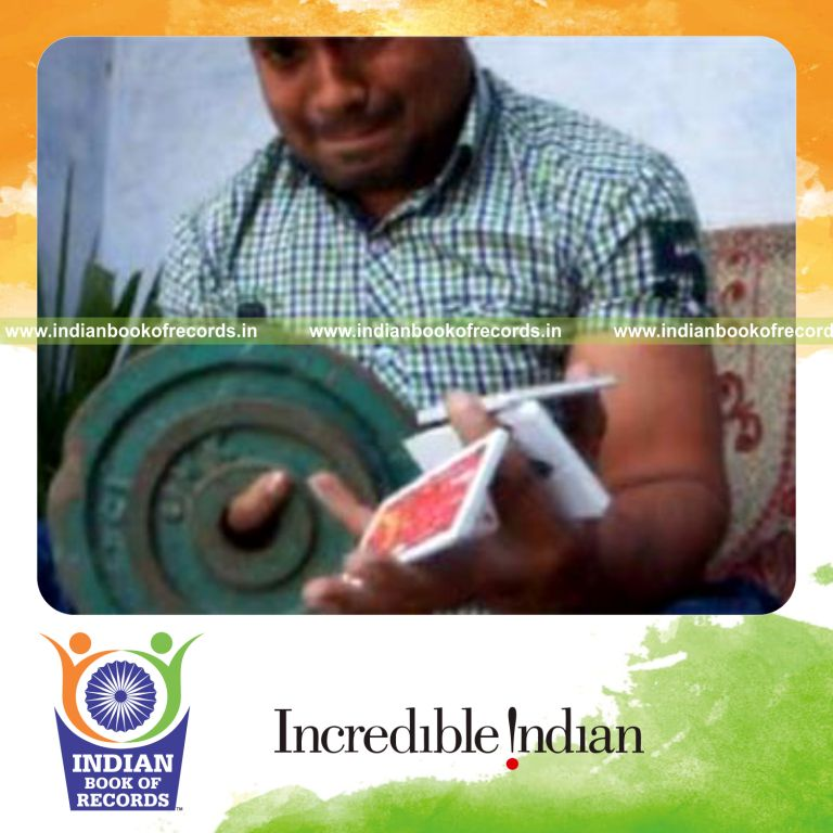 individual performing triple charlier card cuts while holding 20 pound weight plate for record in Indian Book of Records