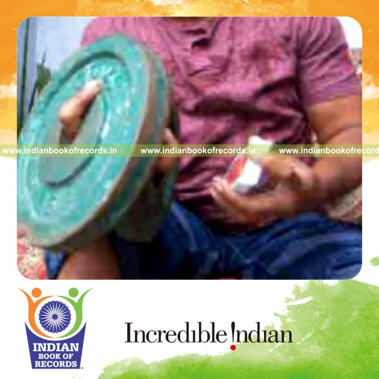 individual performing triple charlier card cuts while holding weight plates for an record in Indian Book of Records