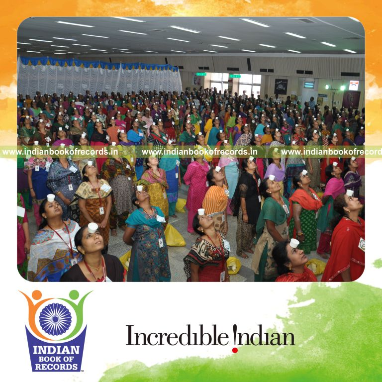 women balancing paper cups on forehead simultaneously for Indian Book of Records