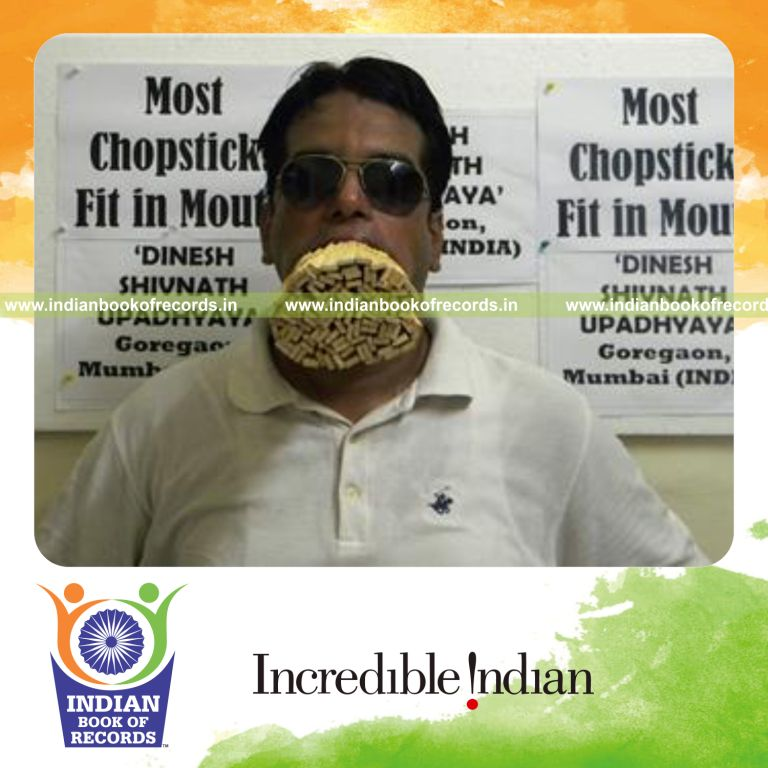 individual fitting wooden chopsticks in mouth for record in Indian Book of Records