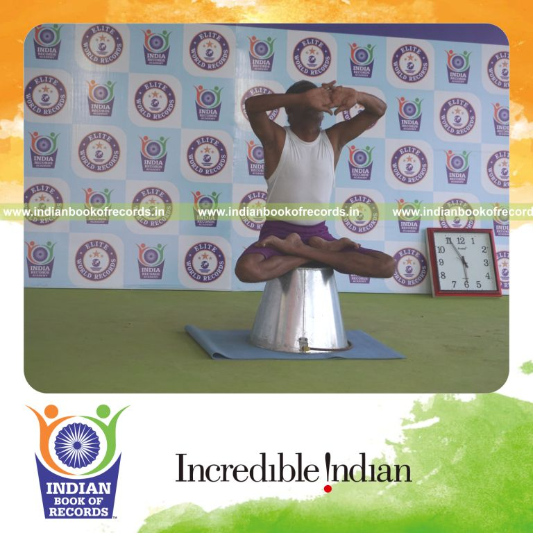 individual performing maximum yogasanas blindfolded on an inverted bucket in 5 minutes for record in Indian Book of Records