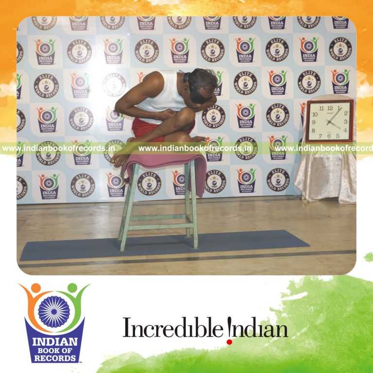 individual performing maximum yogasanas blindfolded on a stool in 15 minutes for record in Indian Book of Records