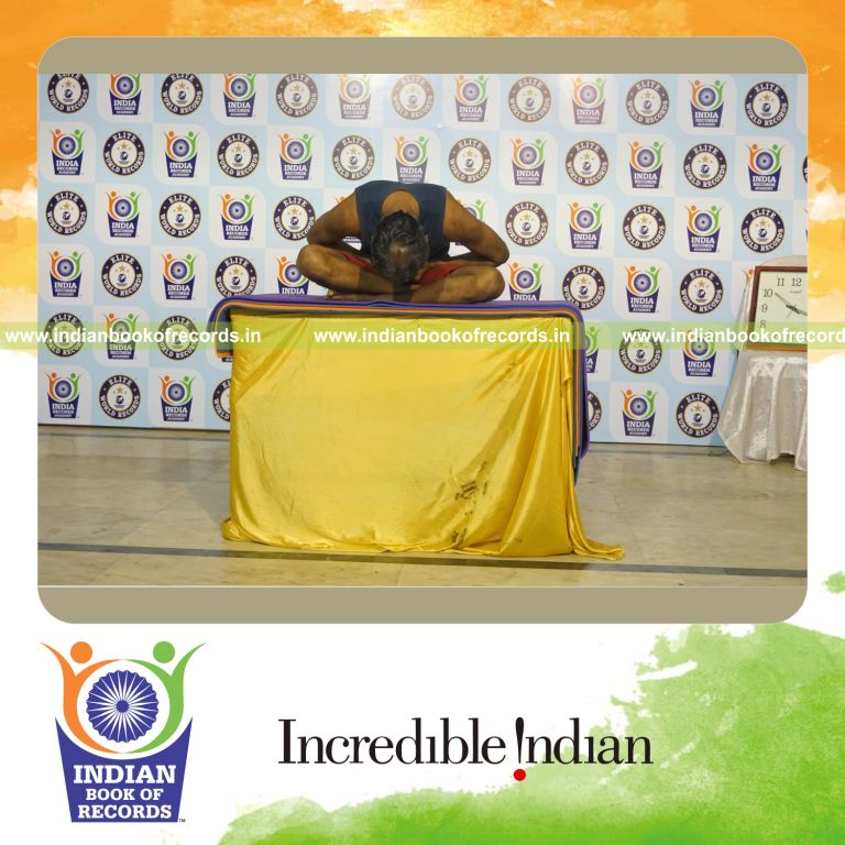 individual performing maximum yogasanas on a table in 15 minutes for record in Indian Book of Records