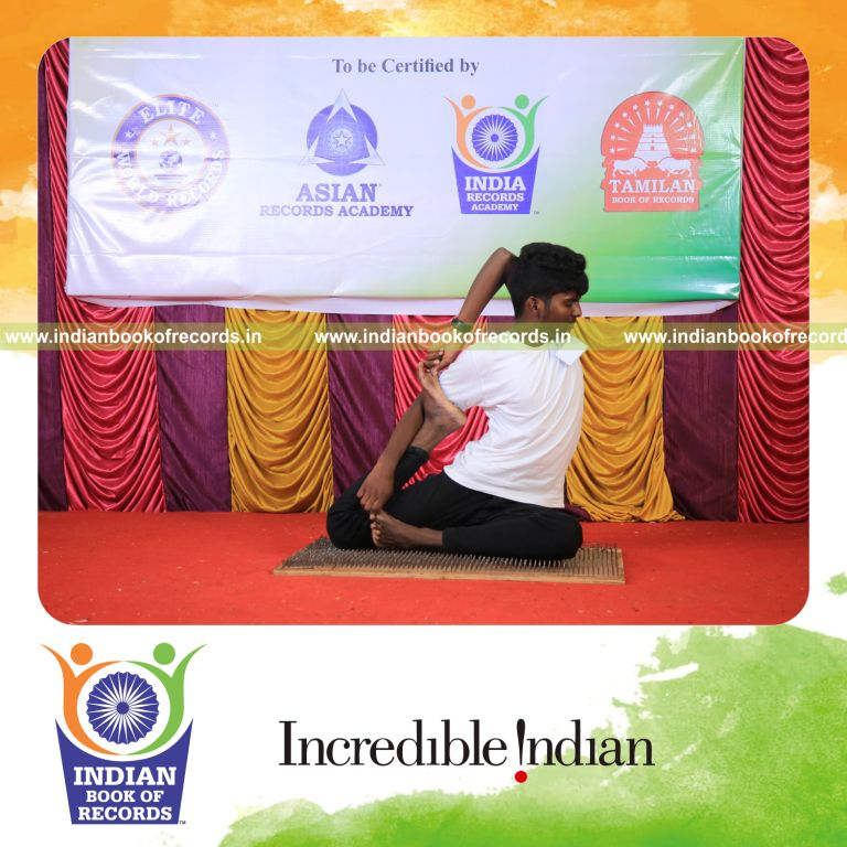 Person solving division problems mentally while balancing on a nail bed in a yoga pose for Indian Book of Records