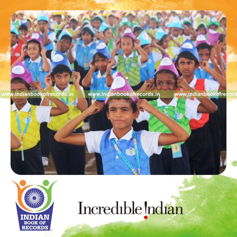 Participants wearing paper hats together in large numbers at one location for Indian Book of Records