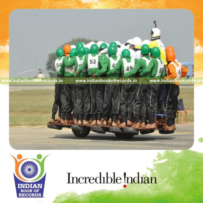 multiple people balancing and riding together on a single motorcycle to set a record for Indian Book of Records