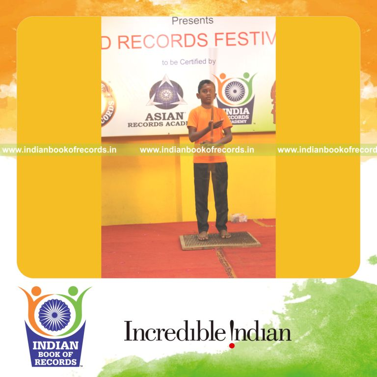 A young individual performing Silambam Nadukombu on a nail bed continuously for the Indian Book of Records