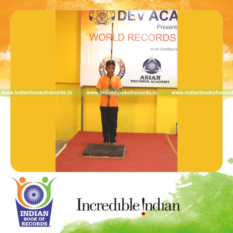 A young performer demonstrating Silambam Ullveechu continuously on a nail bed for the Indian Book of Records