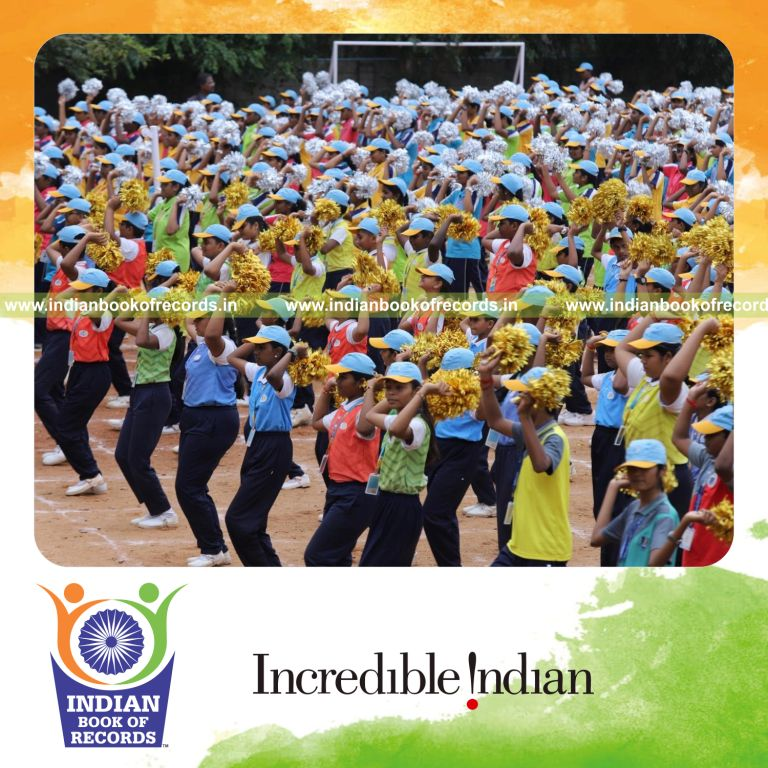 Large group performing sports drills while holding pom poms together at one venue for Indian Book of Records