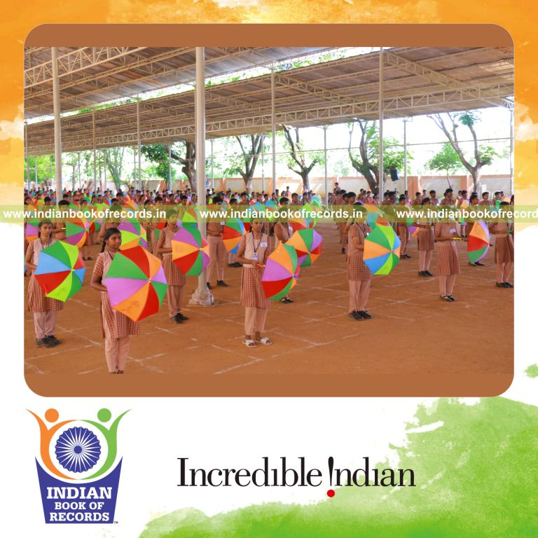 Participants performing a sports drill while holding umbrellas simultaneously at one location for Indian Book of Records