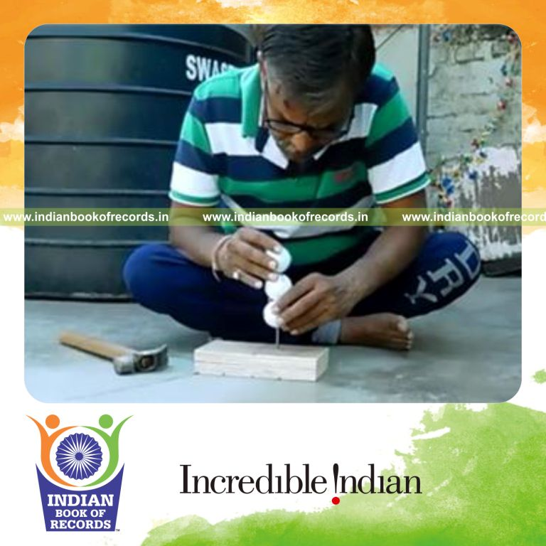 individual stacking golf balls on nail for tallest tower record in Indian Book of Records