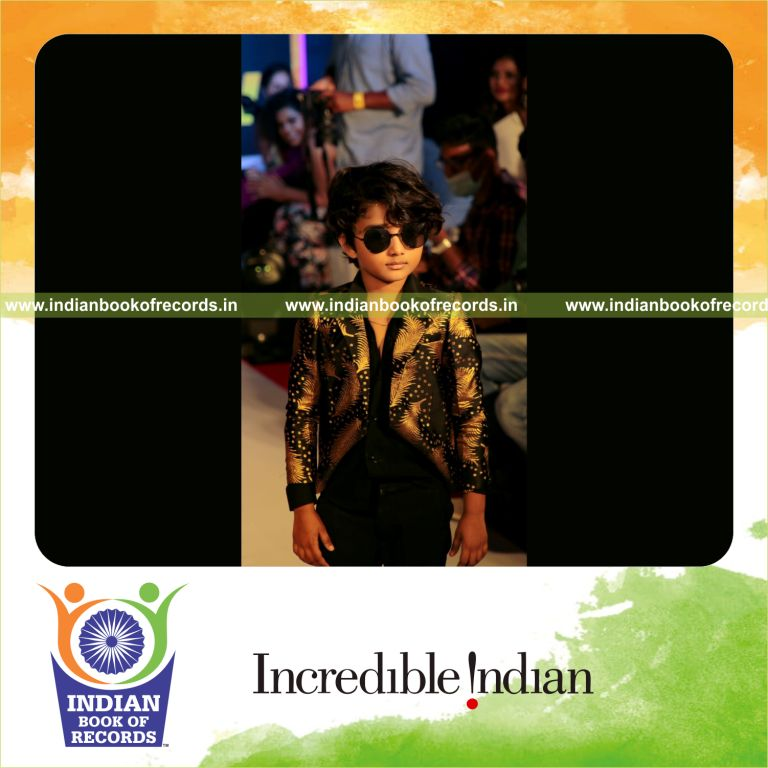 A young participant confidently walking the runway and winning an international fashion show recognized by Indian Book of Records